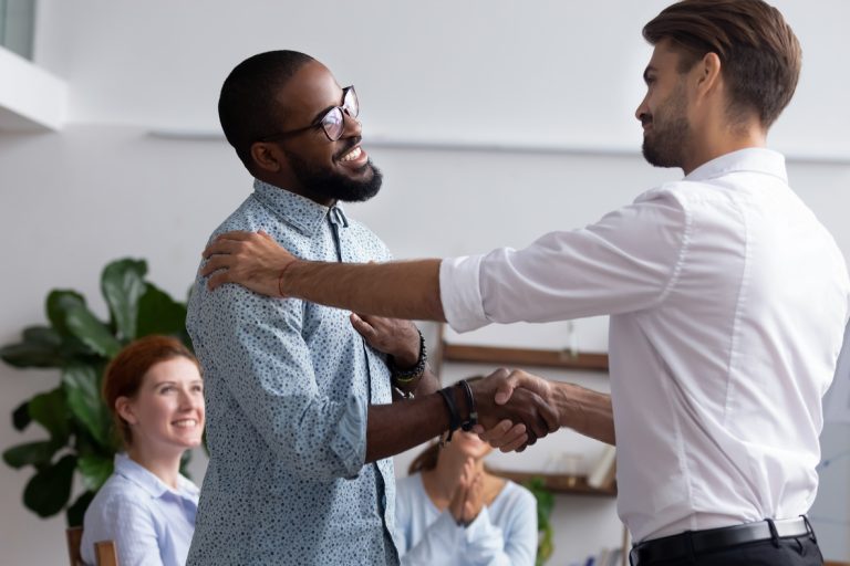 Company boss congratulating handshaking with successful employee