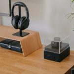 A modern desk setup featuring a monitor, headphones, and decorative items.