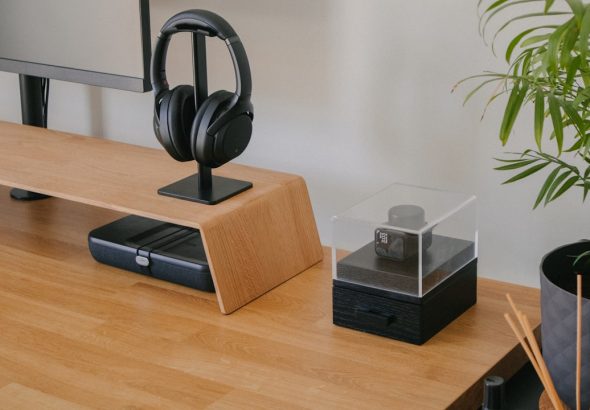 A modern desk setup featuring a monitor, headphones, and decorative items.